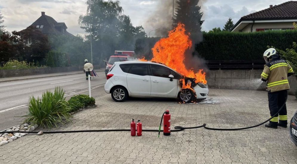 Feuerwehrkraft vor brennendem Auto