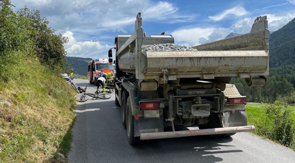 Zwischen einem Lastwagen und einem Rettungswagen liegt ein Fahrrad auf der Strasse