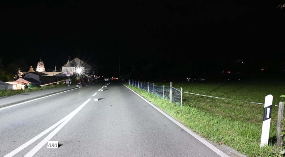 Strasse im Dunkeln mit auf den Mittelstreifen gestellten Zahlenmarkierungen, im Hintergrund Rettungskräfte und ein Auto