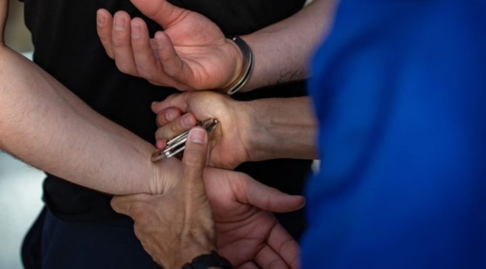 Symbolbild: Polizist legt Handschellen an