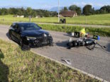 Foto einer Unfallszene, links ein schwarzer Audi mit beschädigter Front, rechts liegt ein Motorrad auf dem Boden