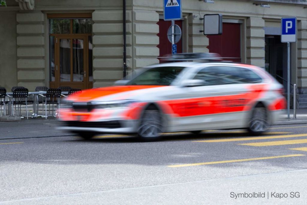 Symbolbild Polizeiauto mit Bewegungsunschärfe vor Häusern