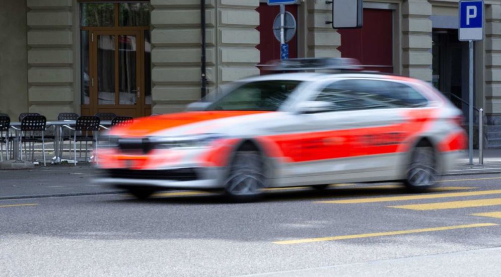 Symbolbild Polizeiauto mit Bewegungsunschärfe vor Häusern