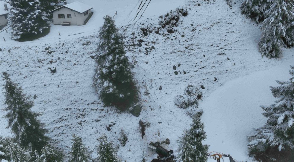 schneebeckter Hang mit abgestürztem Auto, Vogelperspektive