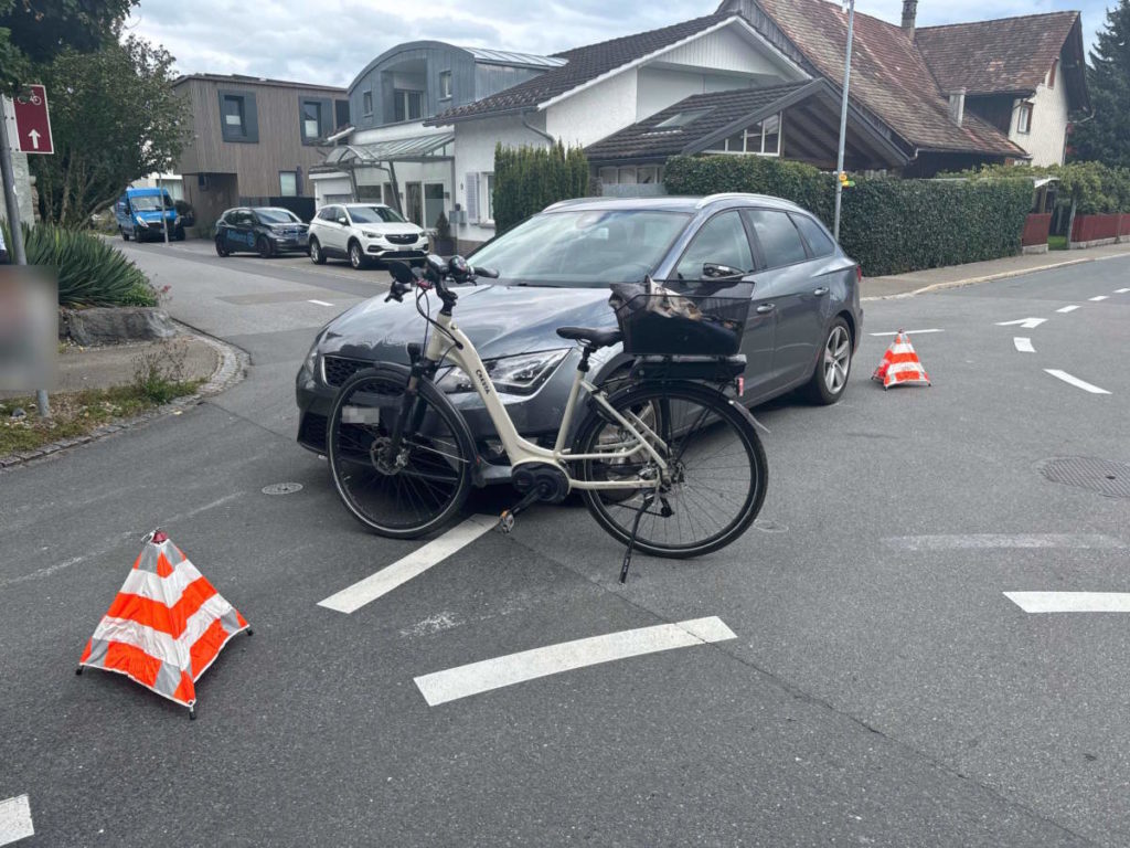 E-Bike vor Auto zwischen zwei Warnpyramiden