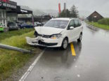 Demolierter weißer Wagen auf regennasser Fahrbahn