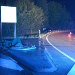 Autobahnausfahrt, am Strassenrand ein Auto im Gebüsch