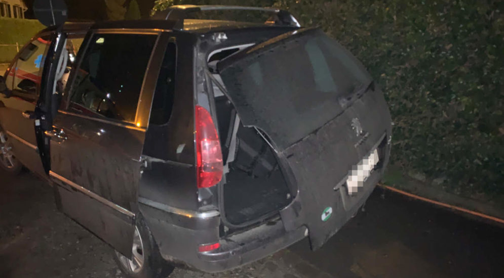 Unfallfoto: Schwarzes Auto mit halb weghängender Hecktür