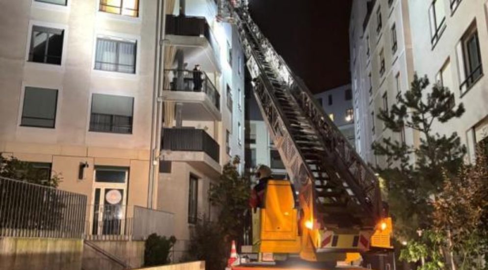 Leiter geht von Feuerwehrauto zu Balkon im vierten Stock