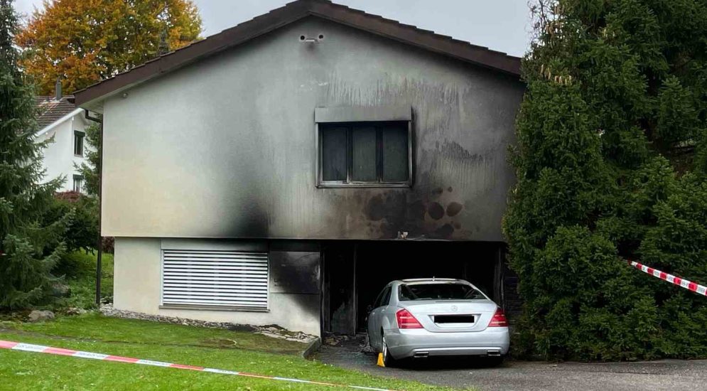 verrusste Hauswand, davor stseht ein Auto