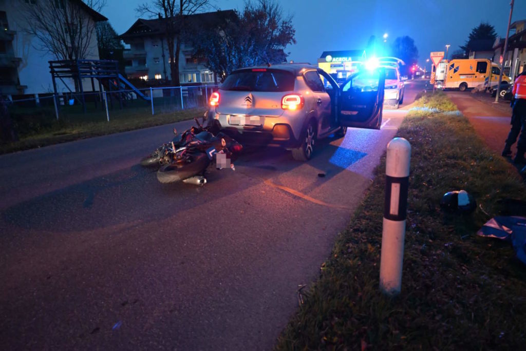 Unfallfoto: Motorrad liegt hinter Autoheck