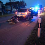 Unfallfoto: Motorrad liegt hinter Autoheck