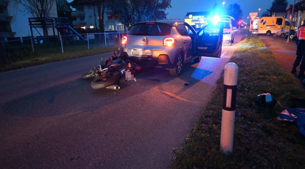 Unfallfoto: Motorrad liegt hinter Autoheck