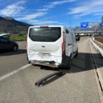 Unfallfoto: weisser Lieferwagen mit leicht beschädigtem Heck auf Autobahn, die Stossstange ist abgefallen