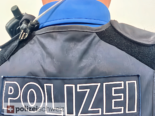 Symbolfoto: Nahaufnahme Rücken von Polizist mit Polizei-Schriftzug