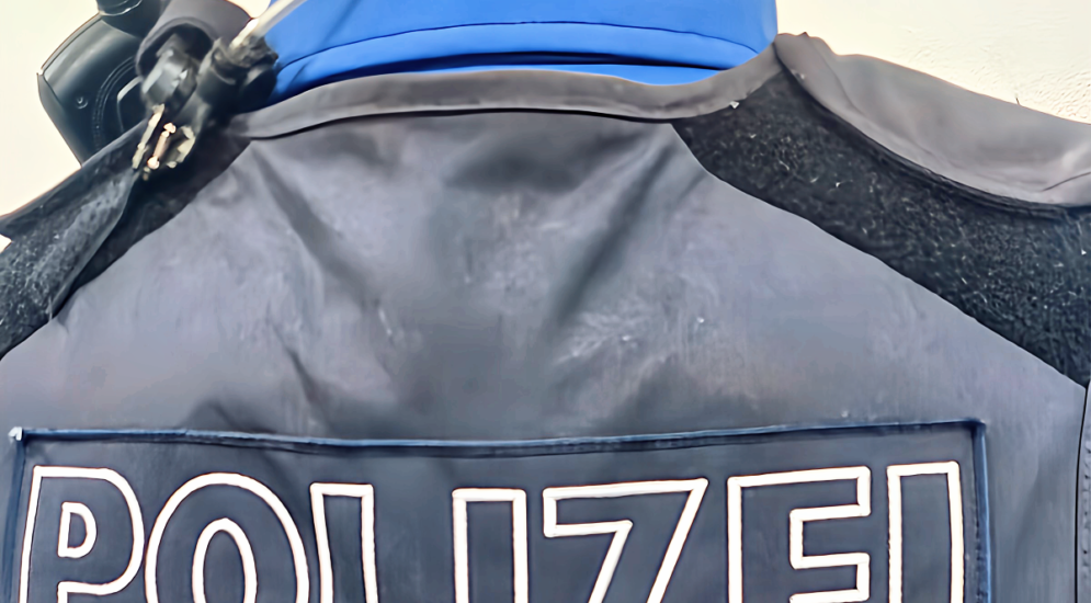 Symbolfoto: Nahaufnahme Rücken von Polizist mit Polizei-Schriftzug