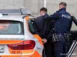 Person in Handstellen wird ins Polizeiauto gebracht