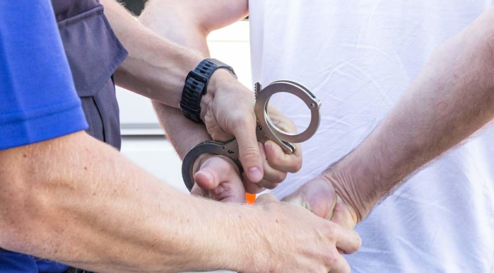 Symbolfoto: Polizist legt Handschellen an