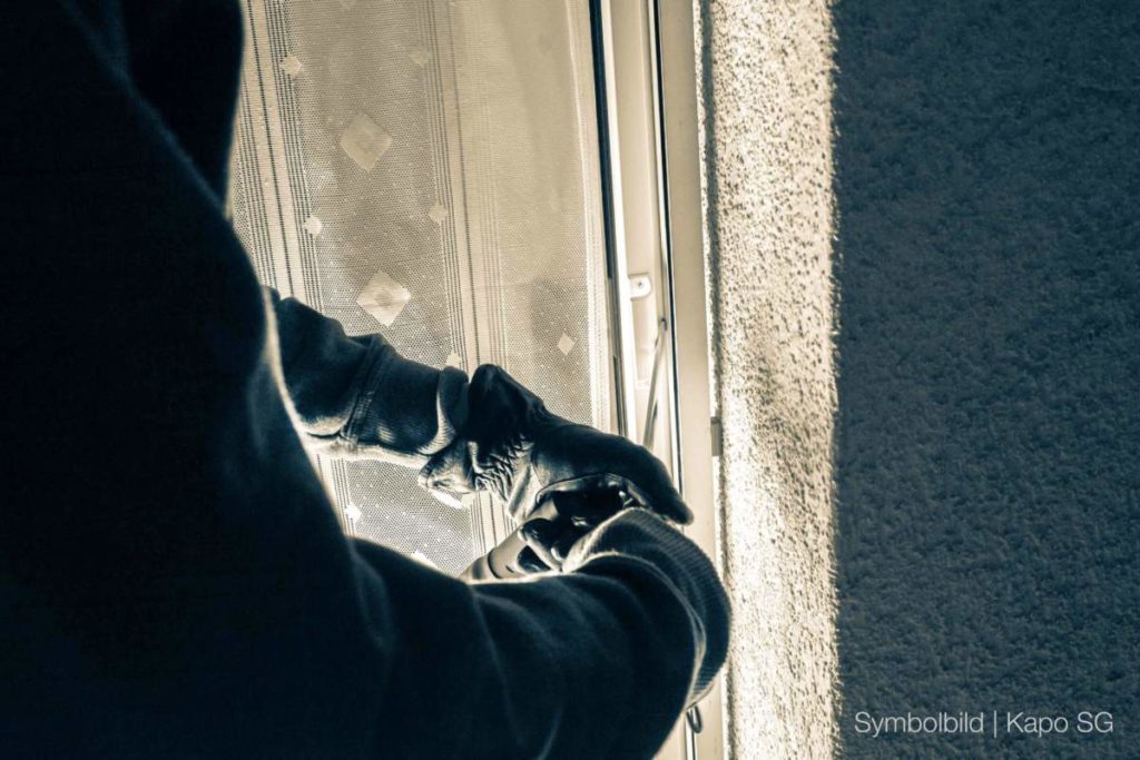 Symbolbild Einbruch: Schwarz behandschuhte Hände machen sich an Fensterrahmen oder Balkontür zu schaffen