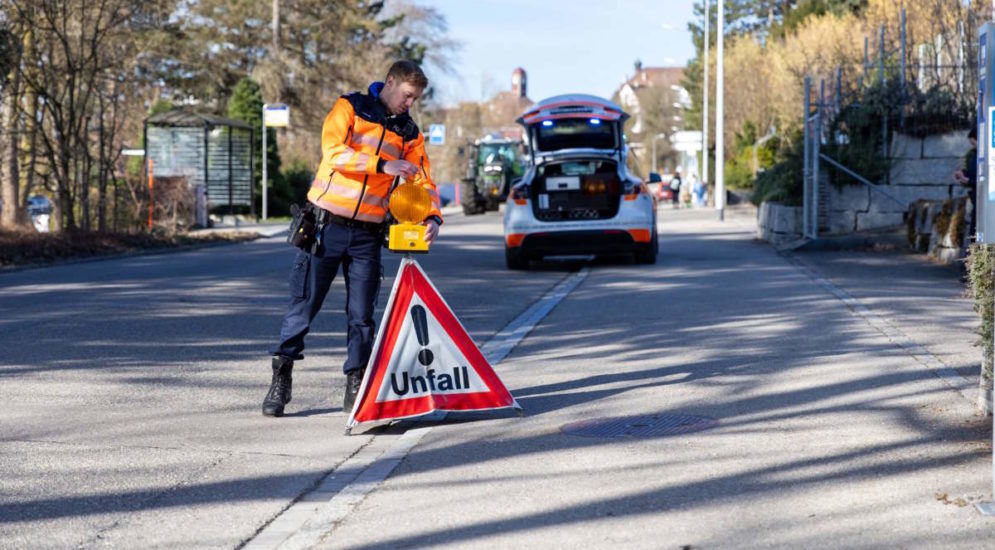 Symbolbild: eine Unfallstelle wird mit Warndreieck abgesichert