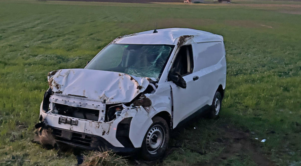 Unfallfoto: Verbeulter weisser Lieferwagen auf Wiese