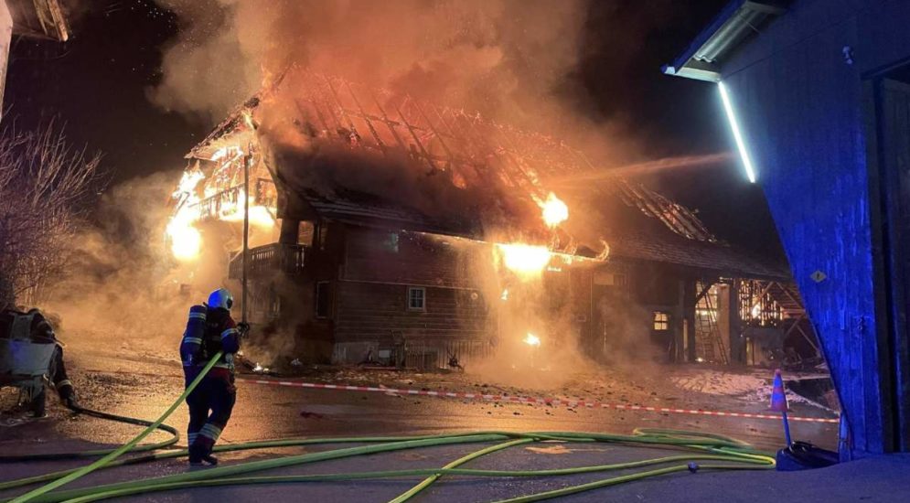 Feuerwehrkraft vor in Vollbrand stehendem Wohnhaus