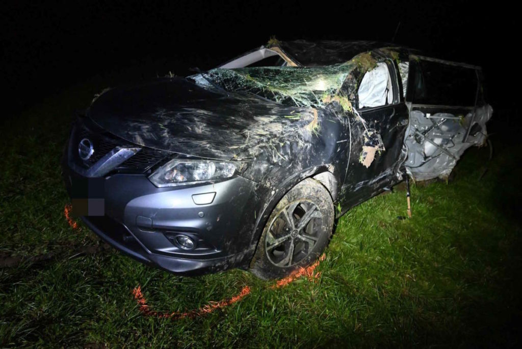 Unfallfoto: schwarzer Nissan mit zersplitterter Windschutzscheibe und eingedrücktem Dach