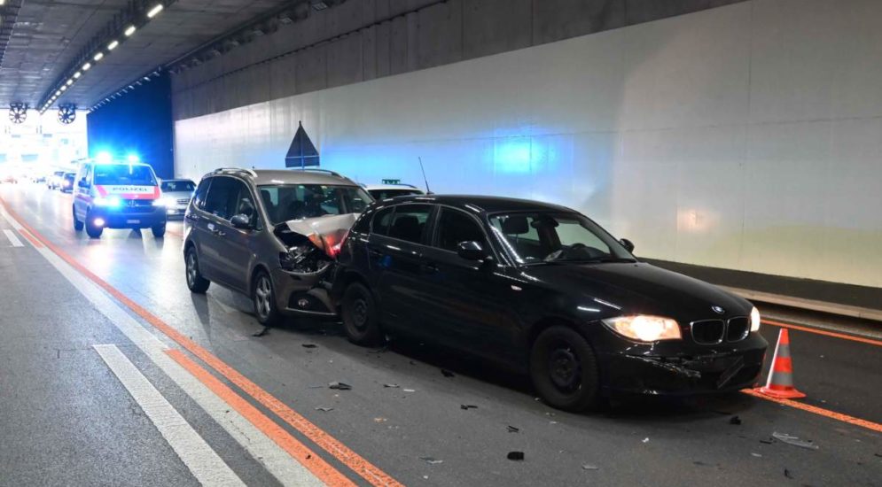 Unfallfoto: schwarzer BMW im Tunnel, dahinter ein graues Auto mit eingedellter Motorhaube