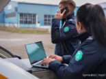 Symbolfoto: Zwei Polizist*innen im Ausseneinsatz, eine Person schreibt am Notebook, eine andere telefoniert